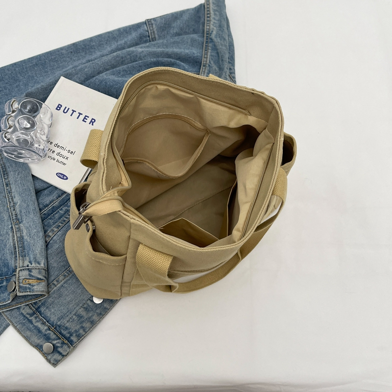 Open the canvas bag to show its internal space and a convenient patch pocket design.